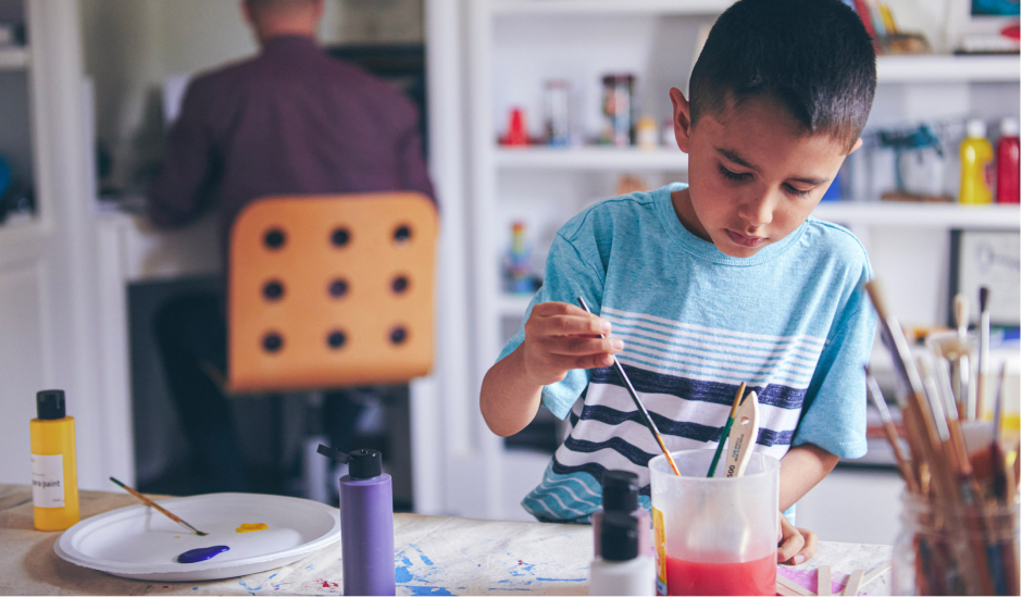 Elementary student painting at home