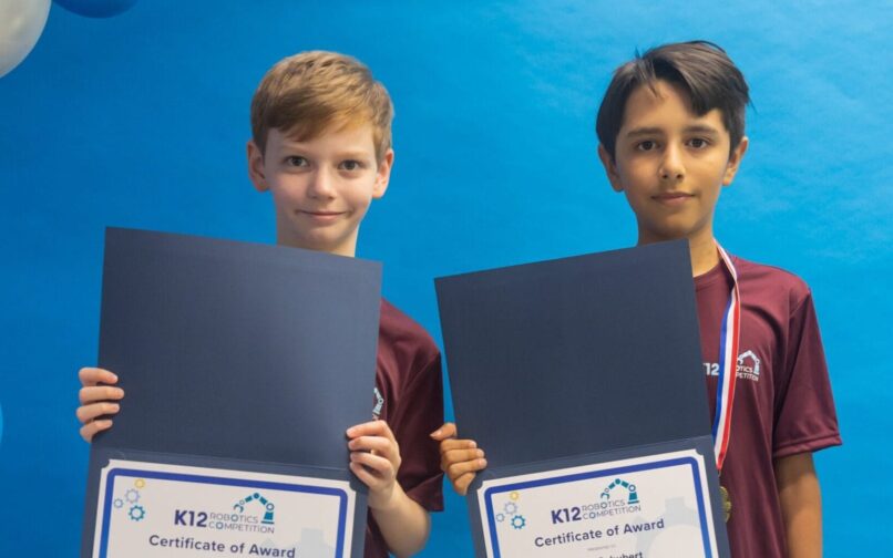 Students holding recognitions of the robotics competition