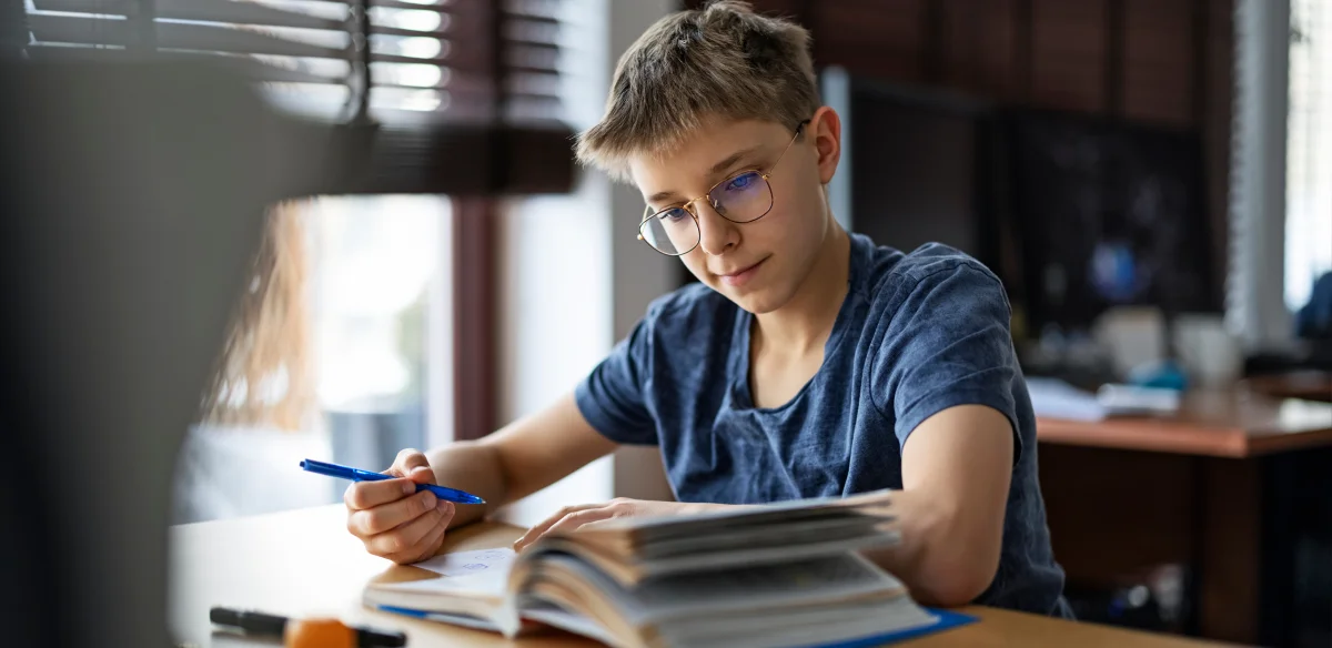 Student taking notes waring glasses